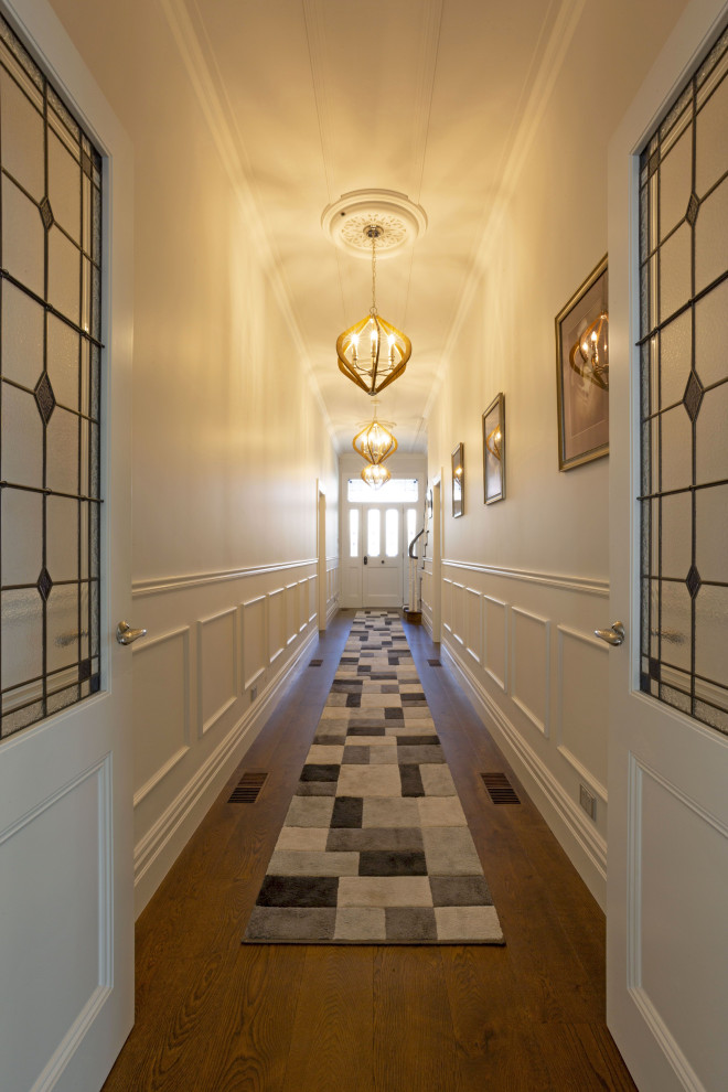 Mittelgroßer Klassischer Flur mit weißer Wandfarbe, dunklem Holzboden, braunem Boden, gewölbter Decke und vertäfelten Wänden in Auckland