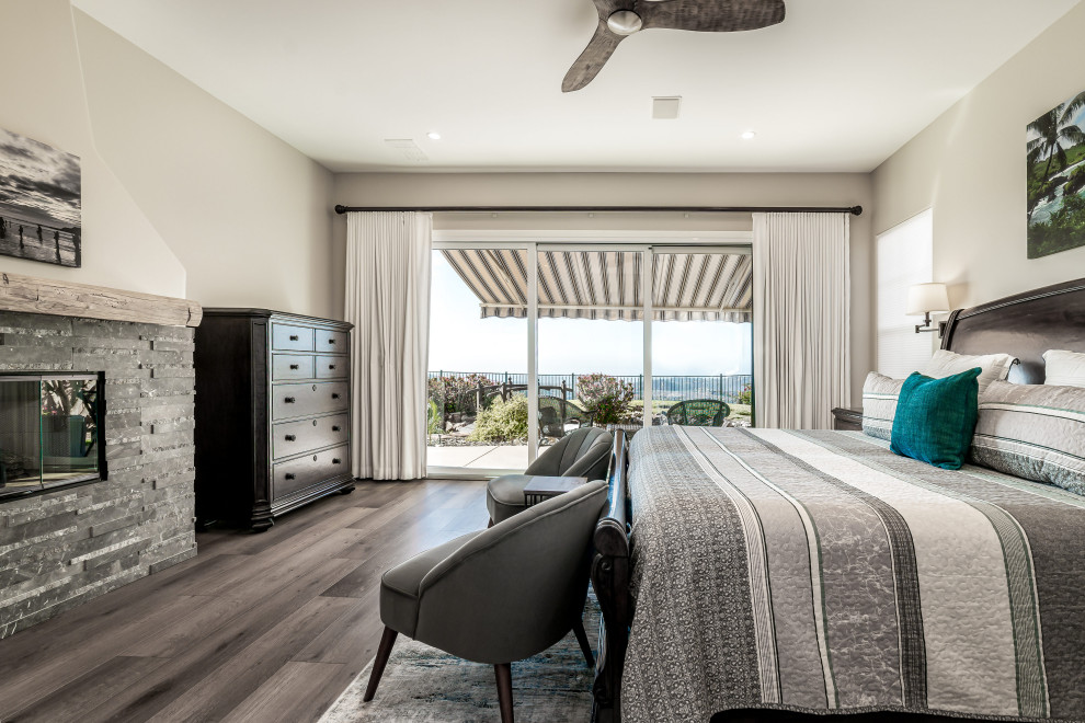 Inspiration for a mid-sized contemporary master bedroom in San Diego with beige walls, vinyl floors, a standard fireplace, a stone fireplace surround and brown floor.
