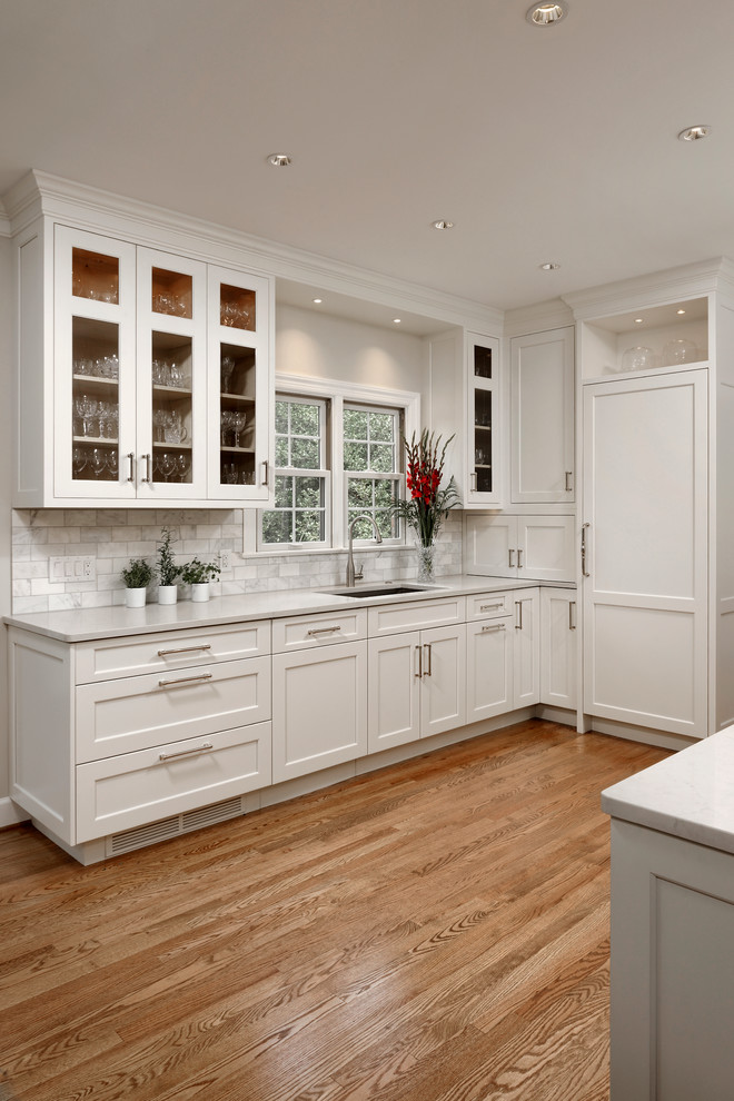 Design ideas for a small transitional u-shaped eat-in kitchen in DC Metro with white cabinets, no island, an undermount sink, recessed-panel cabinets, limestone benchtops, stone tile splashback, panelled appliances, medium hardwood floors, white splashback and beige floor.