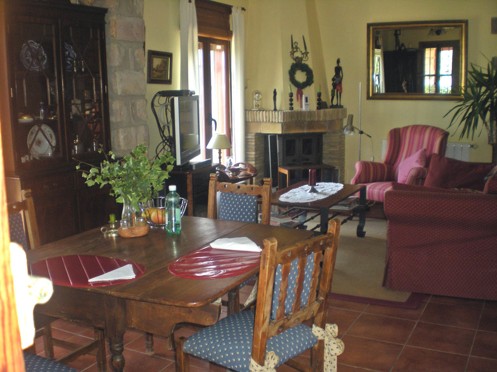 Foto de comedor rústico de tamaño medio abierto con paredes amarillas, suelo de baldosas de terracota y todas las chimeneas