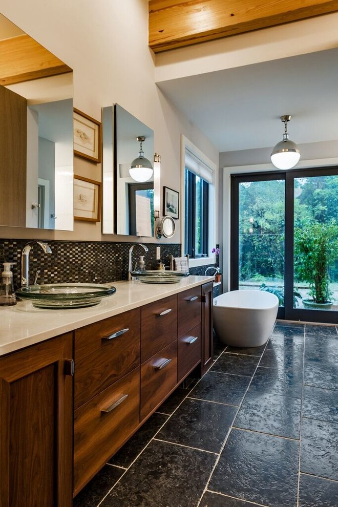 Large transitional master black tile and glass tile porcelain tile freestanding bathtub photo with flat-panel cabinets, dark wood cabinets, a one-piece toilet, white walls, a vessel sink and quartzite countertops