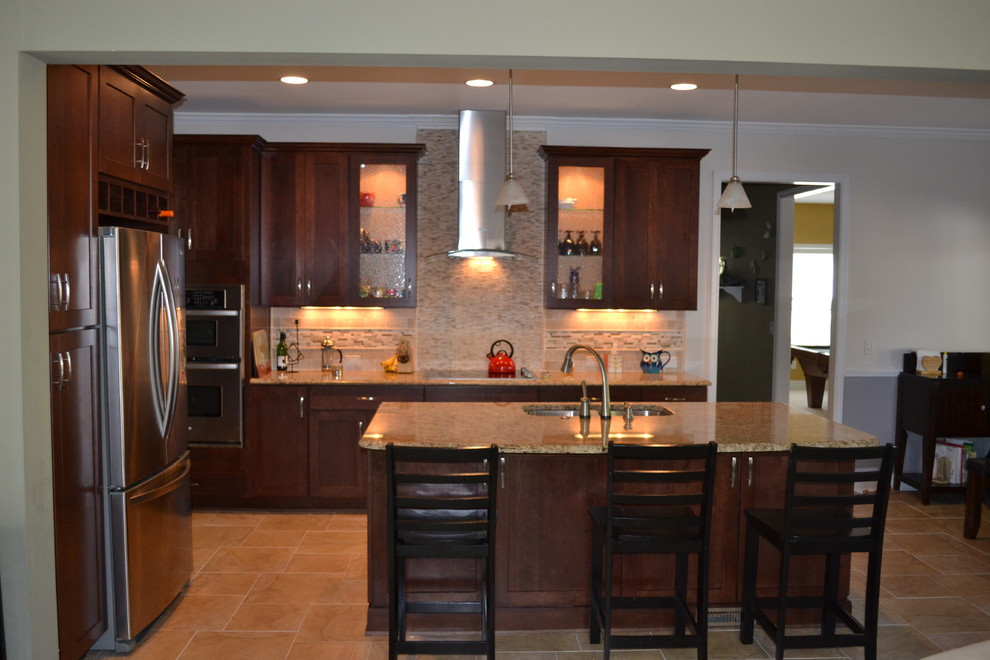 Inspiration for a transitional open concept kitchen remodel in Charlotte with an undermount sink, dark wood cabinets, beige backsplash, stainless steel appliances and an island