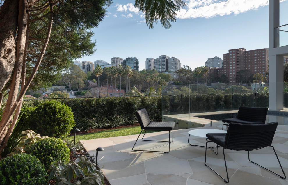 Kleiner Moderner Garten hinter dem Haus mit Natursteinplatten und Holzzaun in Sydney