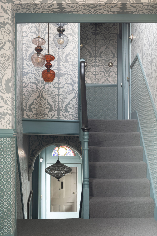 Example of a mid-sized eclectic carpeted u-shaped wood railing and wallpaper staircase design in Sussex with carpeted risers