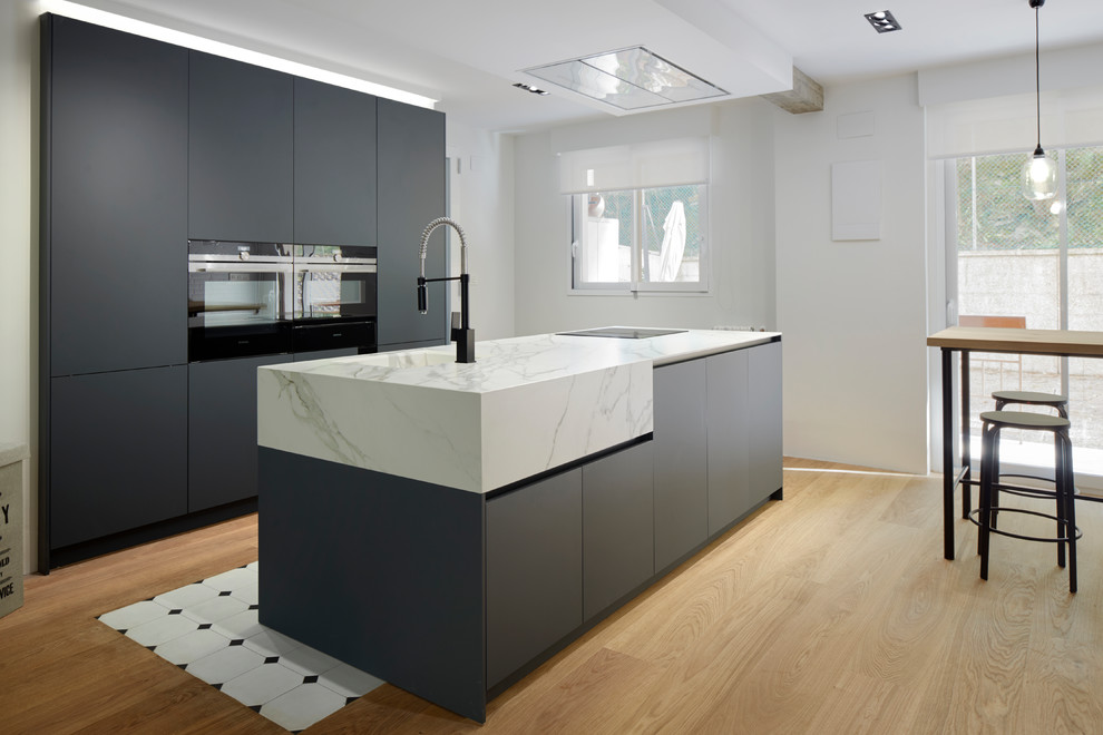 Design ideas for a large industrial galley open plan kitchen in Other with a drop-in sink, open cabinets, black cabinets, marble benchtops, white splashback, brick splashback, stainless steel appliances, porcelain floors, with island and white floor.