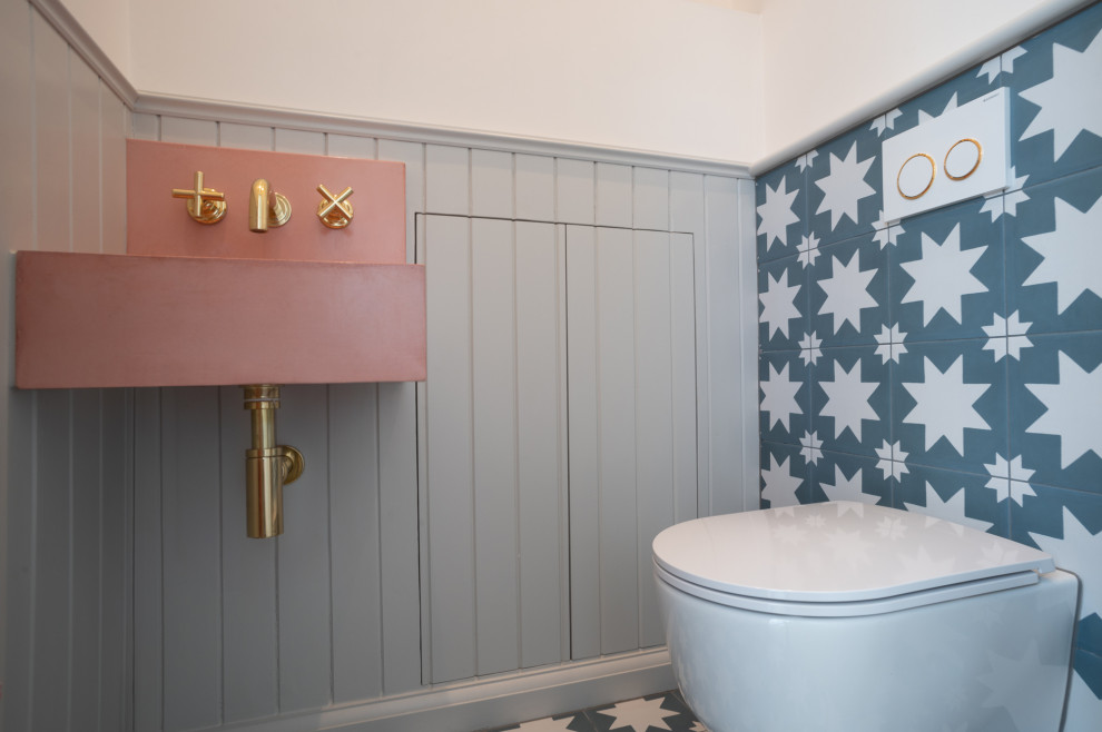 Inspiration pour un WC suspendu traditionnel de taille moyenne avec un carrelage bleu, des carreaux de porcelaine, un mur rose, un sol en carrelage de porcelaine, un lavabo suspendu, un sol bleu et du lambris.
