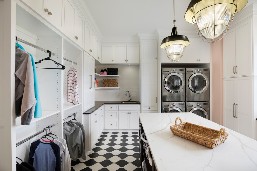 Inspiration for a timeless u-shaped utility room remodel in Minneapolis with an undermount sink, shaker cabinets, white cabinets, pink walls, a stacked washer/dryer and white countertops