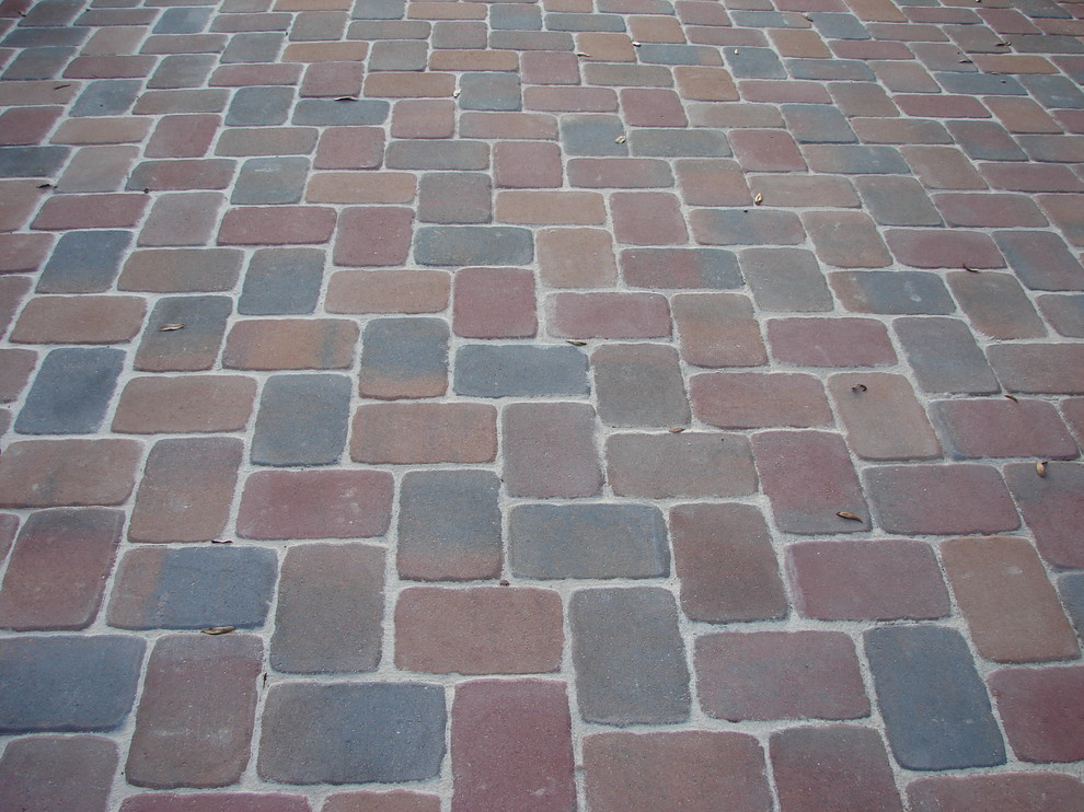 This is an example of a traditional front yard partial sun driveway in Miami with brick pavers.