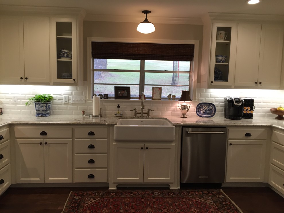 This is an example of a large transitional u-shaped eat-in kitchen in Houston with a farmhouse sink, shaker cabinets, white cabinets, marble benchtops, white splashback, stainless steel appliances, dark hardwood floors and a peninsula.