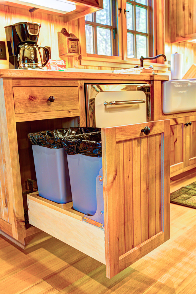 Mid-sized mountain style l-shaped light wood floor eat-in kitchen photo with a farmhouse sink, beaded inset cabinets, light wood cabinets, wood countertops, stainless steel appliances and no island