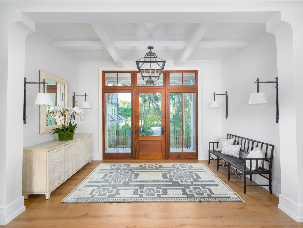 This is an example of a beach style entryway in Charleston with white walls, medium hardwood floors, a single front door, a glass front door, brown floor, coffered and timber.