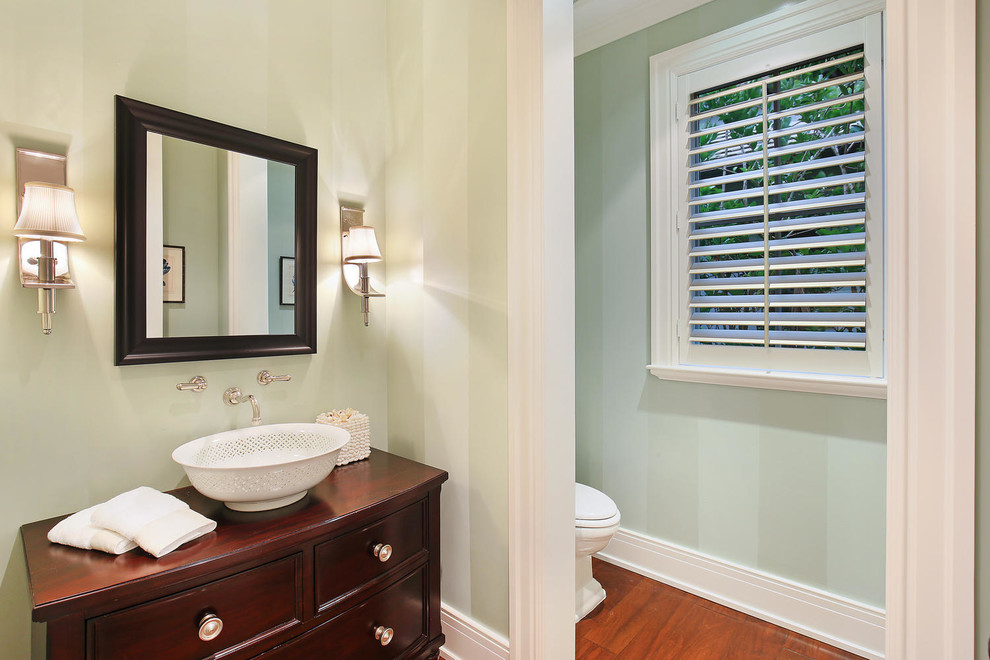 Photo of a large tropical 3/4 bathroom in Tampa with furniture-like cabinets, dark wood cabinets, a two-piece toilet, multi-coloured walls, a vessel sink and marble benchtops.