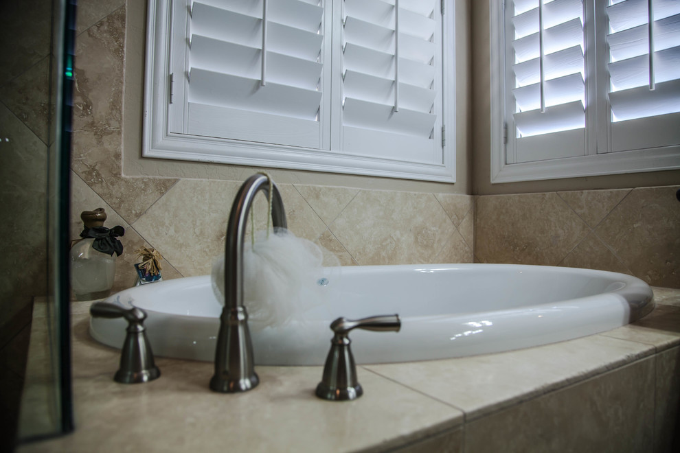 Drop-in bathtub - large transitional master ceramic tile drop-in bathtub idea in Phoenix with raised-panel cabinets, light wood cabinets, beige walls, an undermount sink and granite countertops
