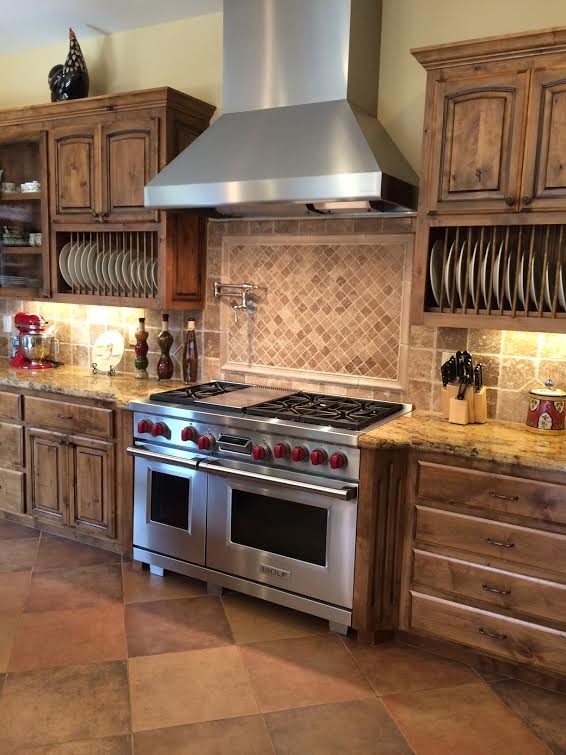 Inspiration for a mid-sized ceramic tile eat-in kitchen remodel in Sacramento with a drop-in sink, raised-panel cabinets, dark wood cabinets, granite countertops, multicolored backsplash, stone tile backsplash, stainless steel appliances and a peninsula