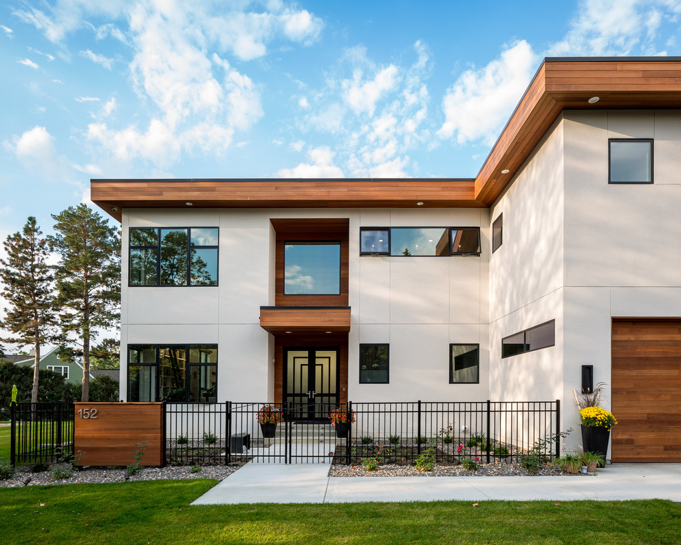 This is an example of an expansive contemporary three-storey white exterior in Minneapolis with mixed siding and a flat roof.