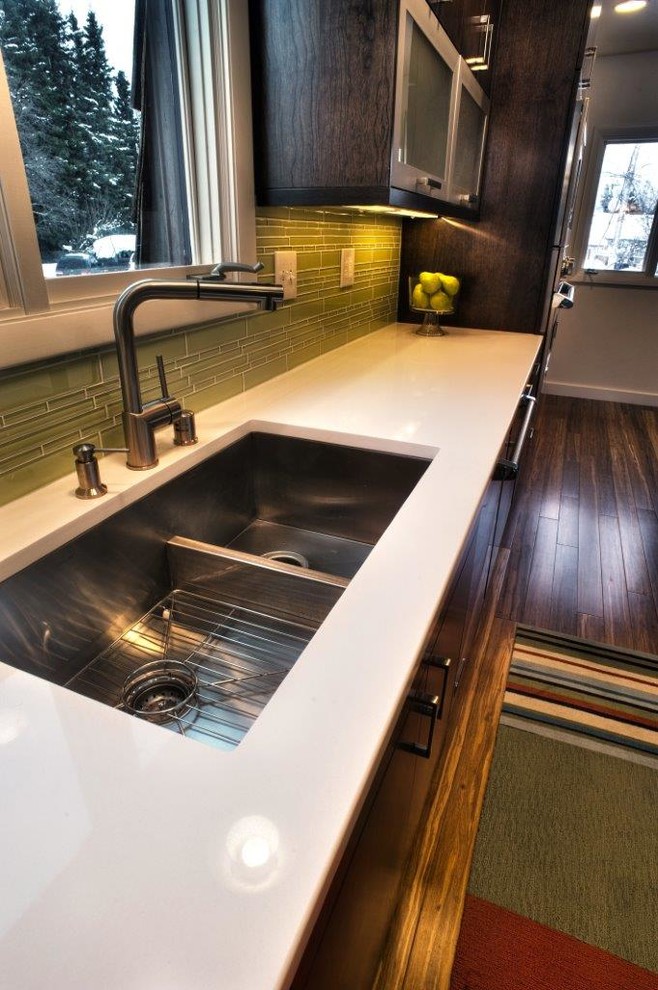 Mid-sized transitional galley dark wood floor and brown floor eat-in kitchen photo with an undermount sink, flat-panel cabinets, dark wood cabinets, quartz countertops, green backsplash, glass tile backsplash, stainless steel appliances and an island