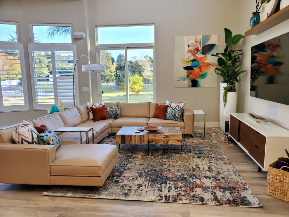 This is an example of a mid-sized midcentury open concept family room in Orange County with beige walls, porcelain floors, no fireplace, a wall-mounted tv and grey floor.