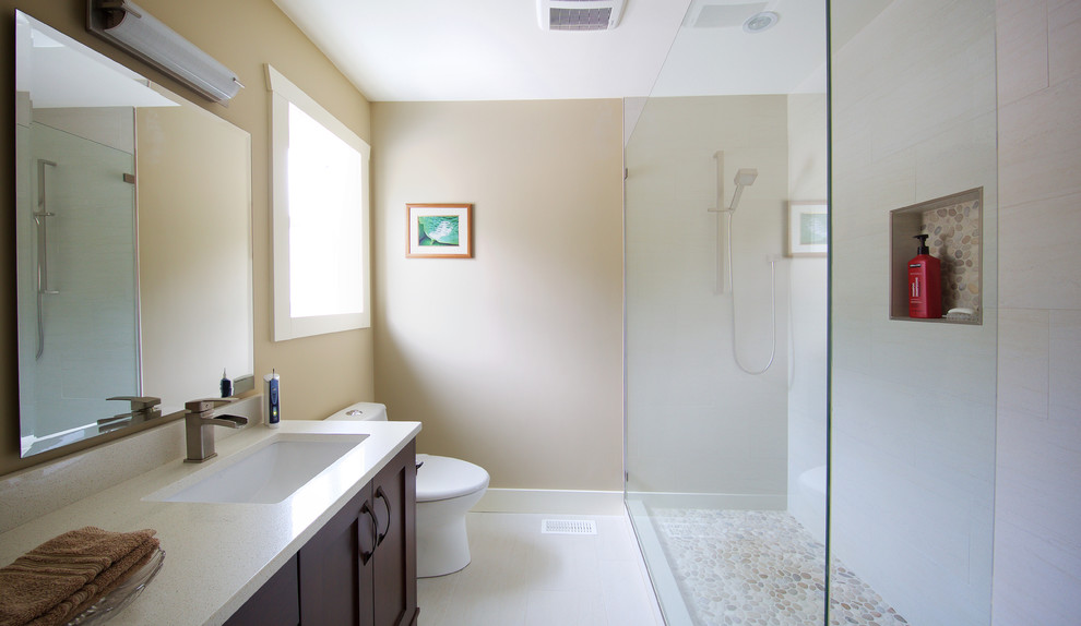 This is an example of a large traditional master bathroom in Vancouver with shaker cabinets, dark wood cabinets, a double shower, a two-piece toilet, white tile, ceramic tile, beige walls, porcelain floors, an undermount sink and engineered quartz benchtops.
