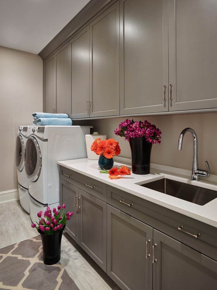 Design ideas for a beach style single-wall dedicated laundry room in Philadelphia with an undermount sink, shaker cabinets, grey cabinets, beige walls and a side-by-side washer and dryer.