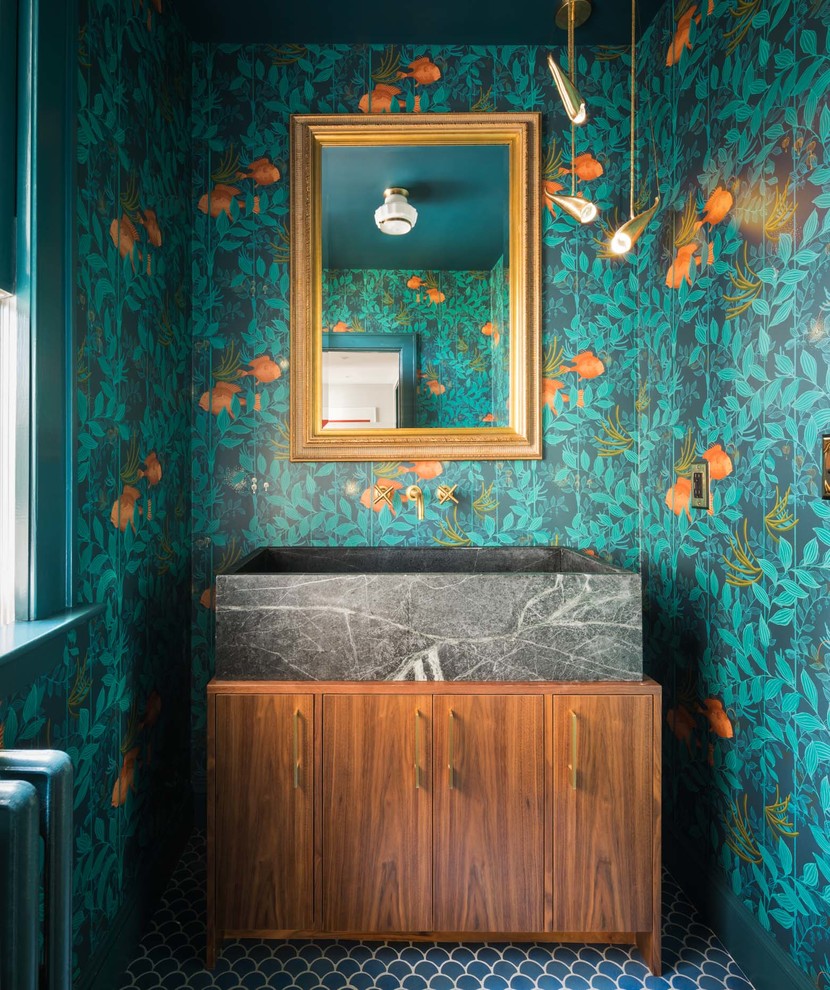 This is an example of a transitional powder room in Portland Maine with flat-panel cabinets, medium wood cabinets, multi-coloured walls, a vessel sink, blue floor, granite benchtops, grey benchtops and a freestanding vanity.