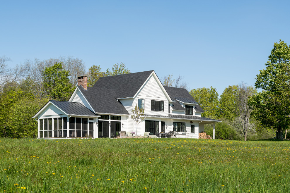 Cette photo montre une façade de maison blanche nature en bois et planches et couvre-joints de taille moyenne et à un étage avec un toit à deux pans, un toit en shingle et un toit gris.
