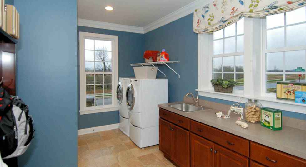 Laundry room in DC Metro with raised-panel cabinets, medium wood cabinets, solid surface benchtops, blue walls and ceramic floors.