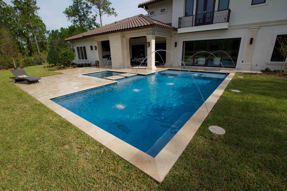 Pool fountain - large backyard stone and custom-shaped natural pool fountain idea in Jacksonville