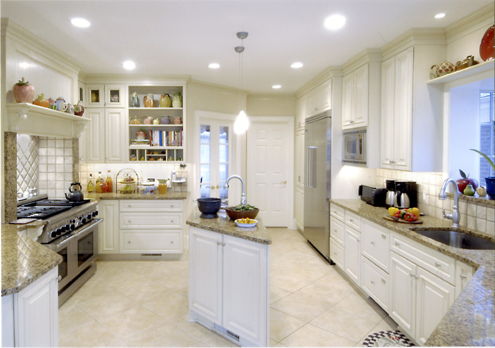 Traditional u-shaped open plan kitchen in DC Metro with a single-bowl sink, beaded inset cabinets, white cabinets, granite benchtops, beige splashback, ceramic splashback, stainless steel appliances, ceramic floors and with island.