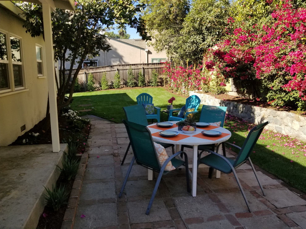 Photo of a mid-sized midcentury backyard patio in Los Angeles with concrete slab and a roof extension.