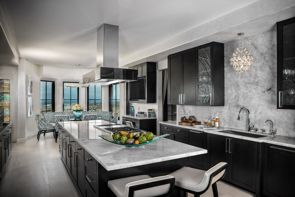 Example of a tuscan beige floor eat-in kitchen design with an island, an undermount sink, shaker cabinets, black cabinets, gray backsplash and gray countertops