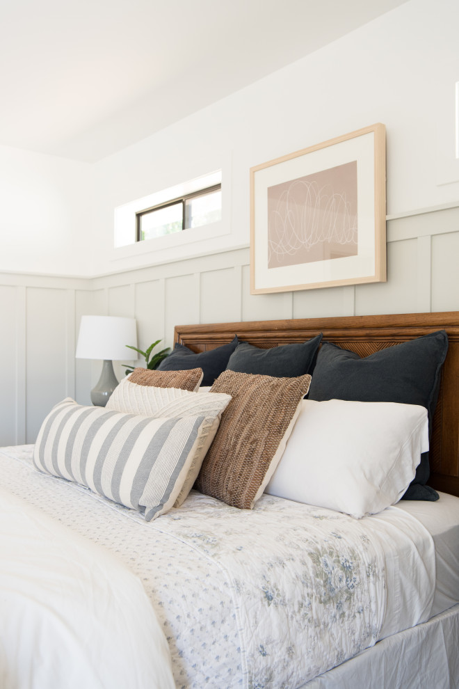 Modelo de dormitorio principal clásico renovado de tamaño medio con paredes beige y boiserie