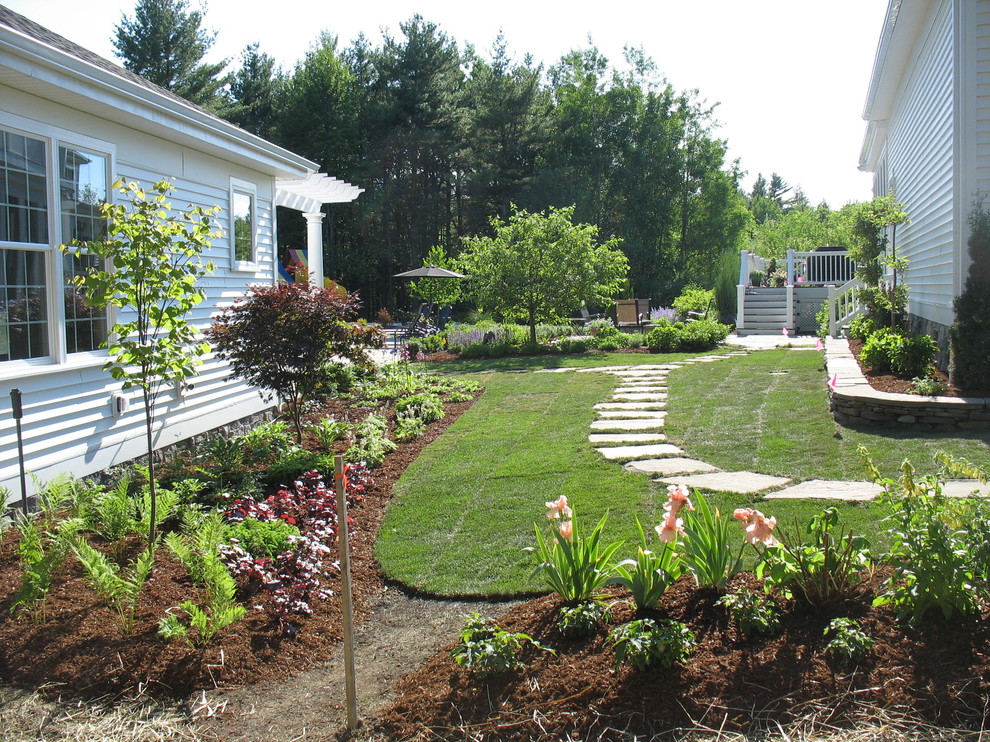 Photo of a traditional side yard partial sun formal garden in Burlington with a garden path and natural stone pavers.