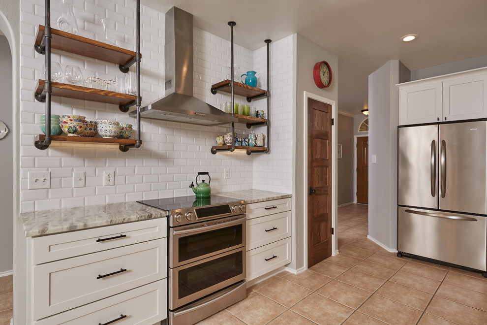 This is an example of a modern kitchen in Austin with shaker cabinets, white cabinets, white splashback, subway tile splashback, stainless steel appliances, multi-coloured floor and multi-coloured benchtop.