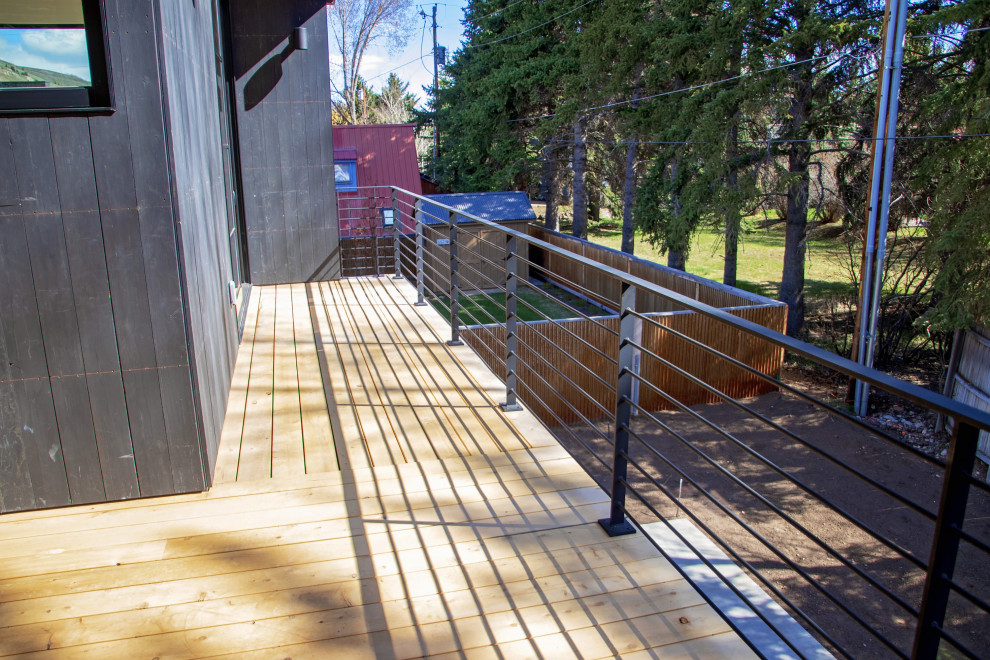 Photo of a backyard deck in Other with with privacy feature and a roof extension.