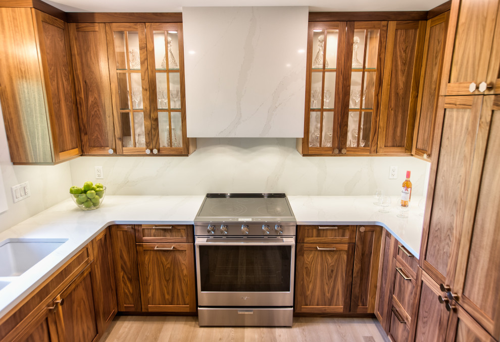 Eat-in kitchen - mid-sized transitional u-shaped light wood floor and gray floor eat-in kitchen idea with an undermount sink, shaker cabinets, brown cabinets, quartz countertops, white backsplash, quartz backsplash, stainless steel appliances, no island and white countertops