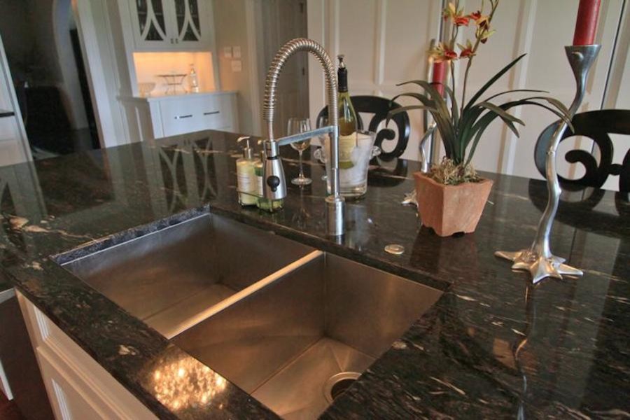 Inspiration for a mid-sized transitional u-shaped dark wood floor enclosed kitchen remodel with a drop-in sink, flat-panel cabinets, white cabinets, granite countertops, white backsplash, stainless steel appliances and an island