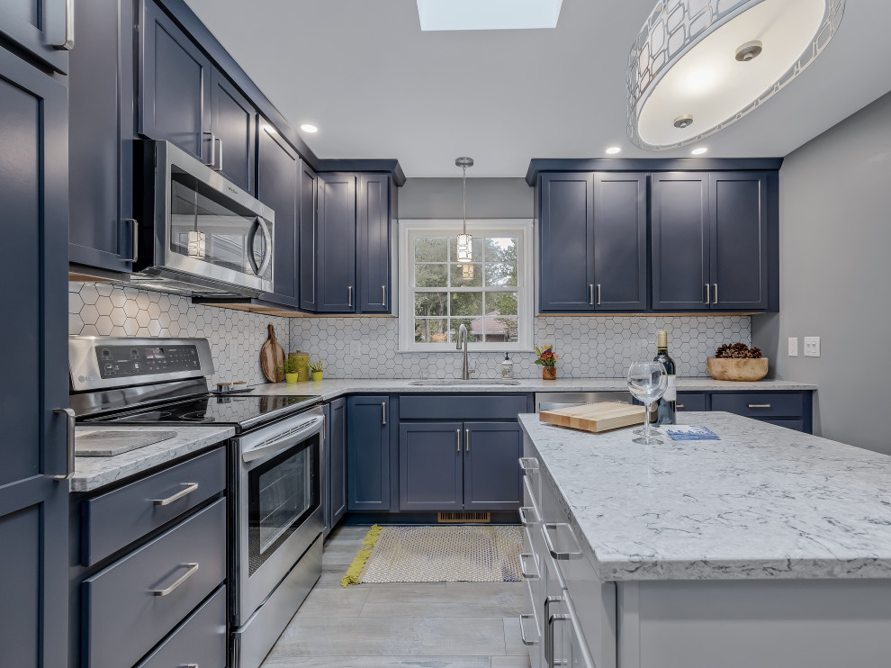 Kitchen - large transitional l-shaped kitchen idea in Raleigh with an undermount sink, recessed-panel cabinets, quartz countertops, porcelain backsplash, stainless steel appliances and an island