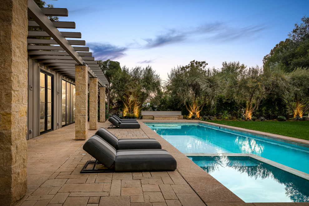Landhausstil Pool hinter dem Haus mit Natursteinplatten in Los Angeles