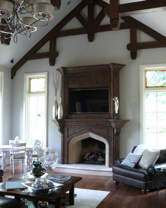 Photo of a mid-sized country open concept living room in Chicago with a built-in media wall, grey walls, dark hardwood floors, a standard fireplace, a stone fireplace surround and brown floor.