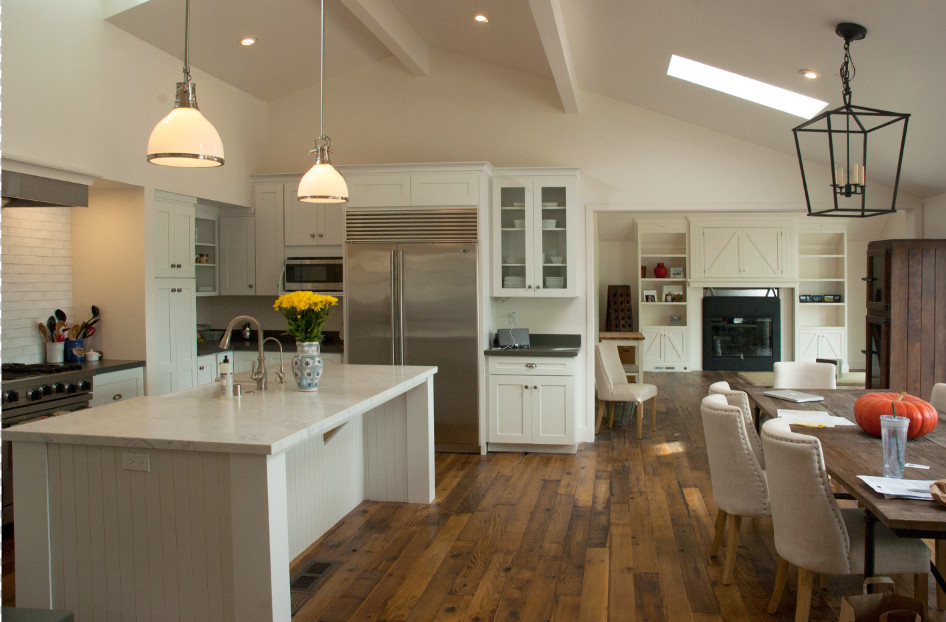 Photo of a country single-wall open plan kitchen in San Francisco with shaker cabinets, white cabinets, white splashback, subway tile splashback, stainless steel appliances, dark hardwood floors and with island.