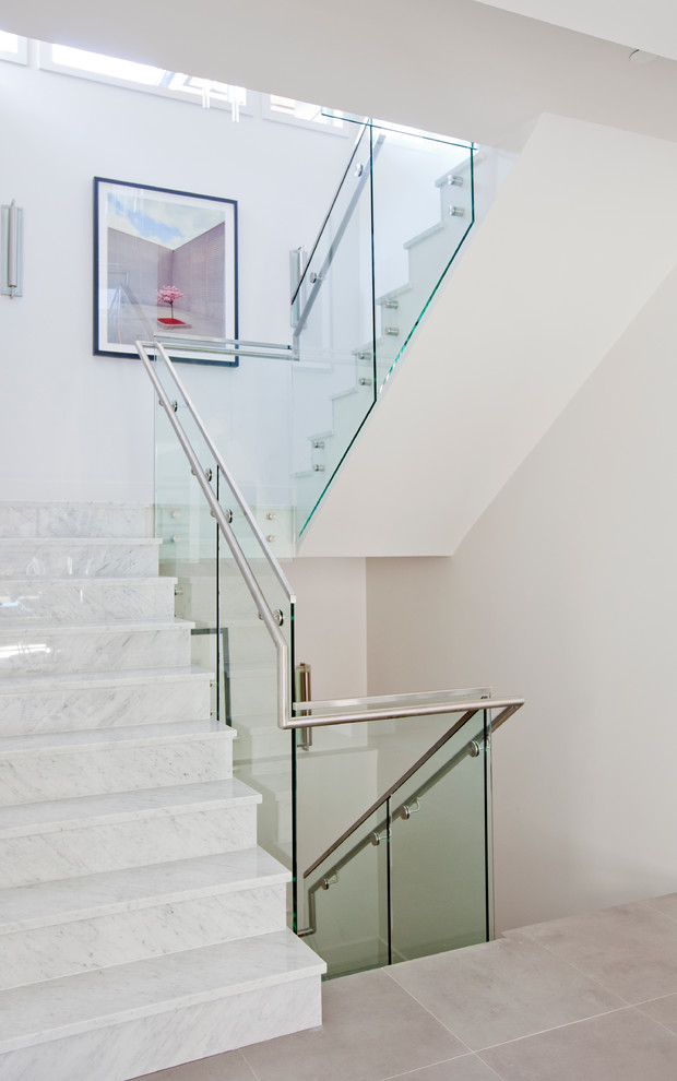 This is an example of a mid-sized contemporary marble u-shaped staircase in Vancouver with marble risers.