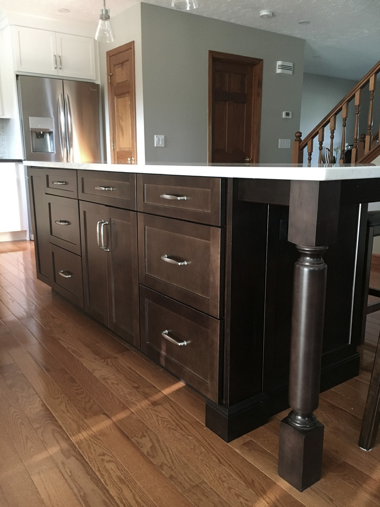 Large transitional single-wall medium tone wood floor eat-in kitchen photo with an undermount sink, shaker cabinets, white cabinets, granite countertops, multicolored backsplash, marble backsplash, stainless steel appliances, an island and black countertops