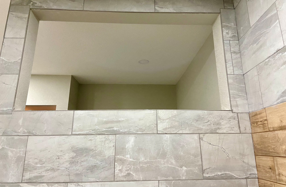 Cette image montre une grande salle de bain design avec une douche ouverte, un carrelage gris, des carreaux de céramique, un sol en carrelage de céramique, un sol gris, aucune cabine et un banc de douche.
