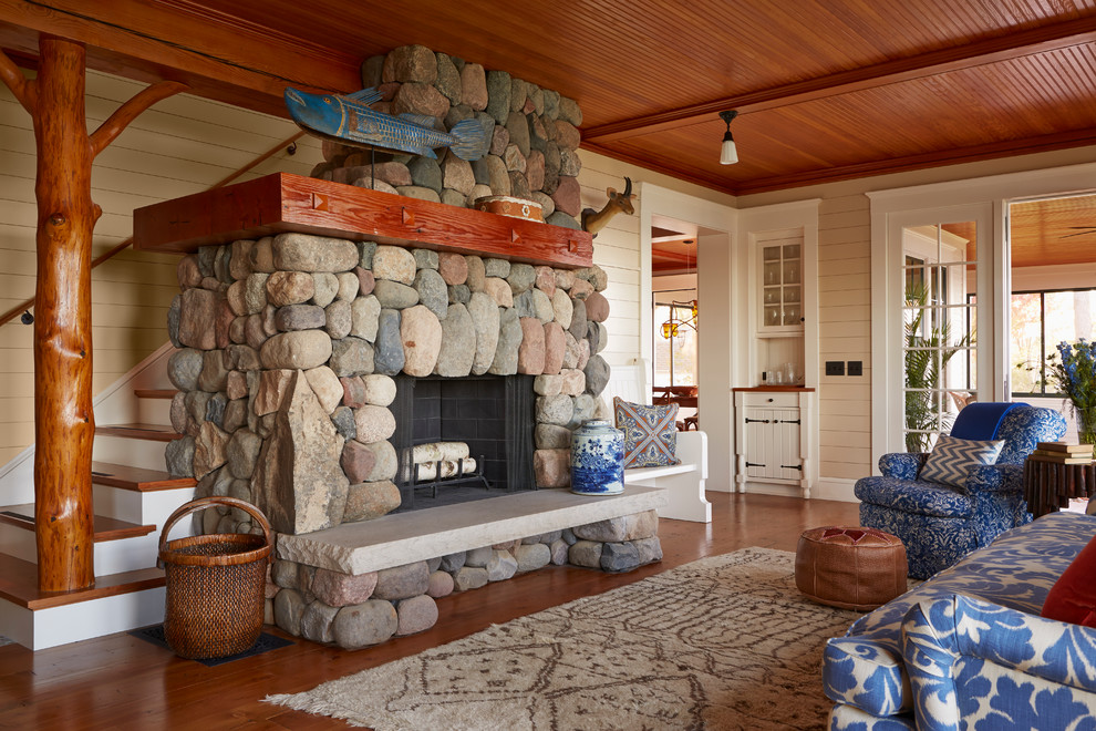 Photo of a beach style enclosed living room in Minneapolis with medium hardwood floors, a standard fireplace, a stone fireplace surround and beige walls.