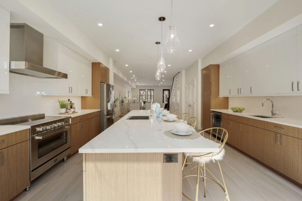 Design ideas for a contemporary galley kitchen in DC Metro with an undermount sink, shaker cabinets, brown cabinets, stainless steel appliances, light hardwood floors, with island, brown floor and white benchtop.