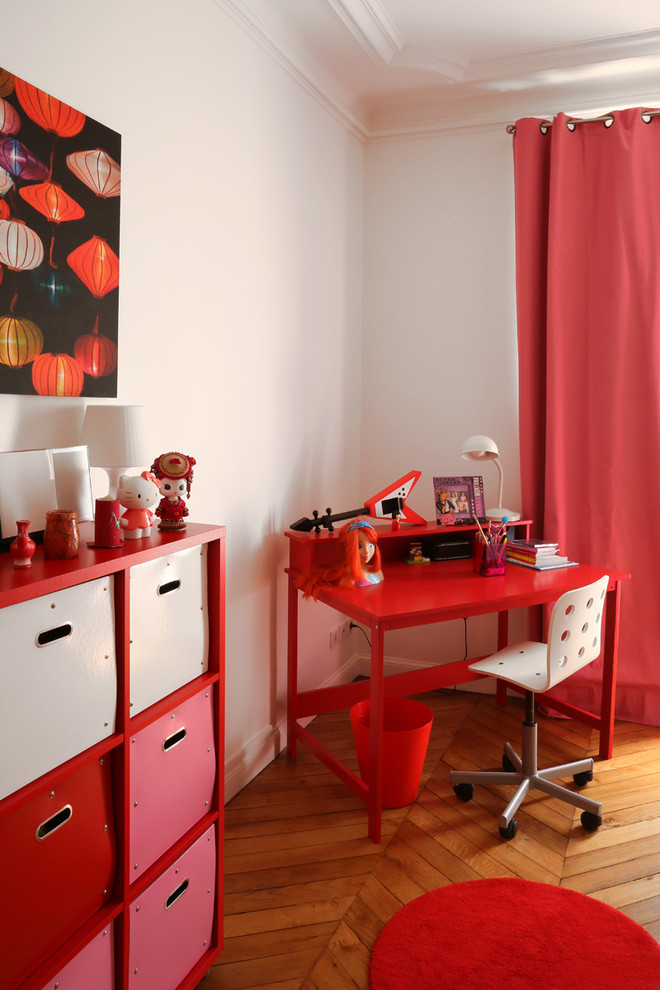 Cette photo montre chambre de garçon pour garçon avec un bureau, un mur blanc et un sol en bois brun.