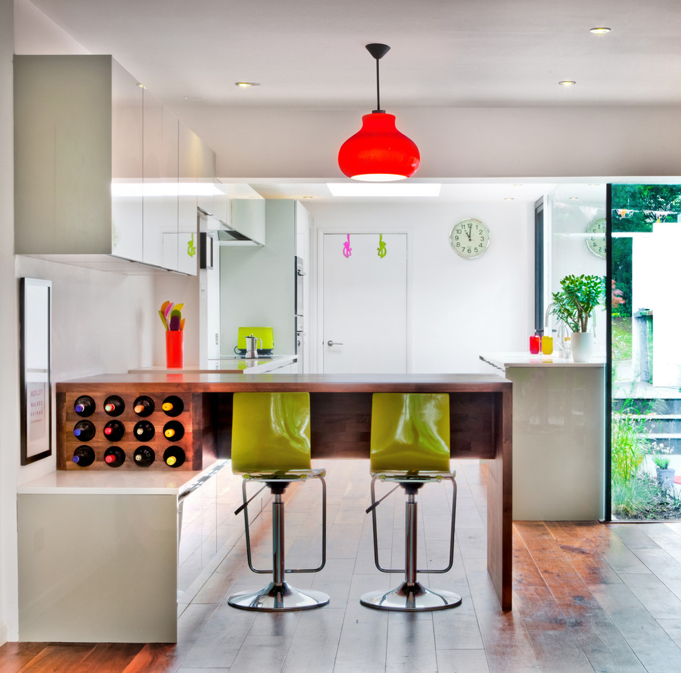 Inspiration for a contemporary single-wall eat-in kitchen in London with flat-panel cabinets and a peninsula.