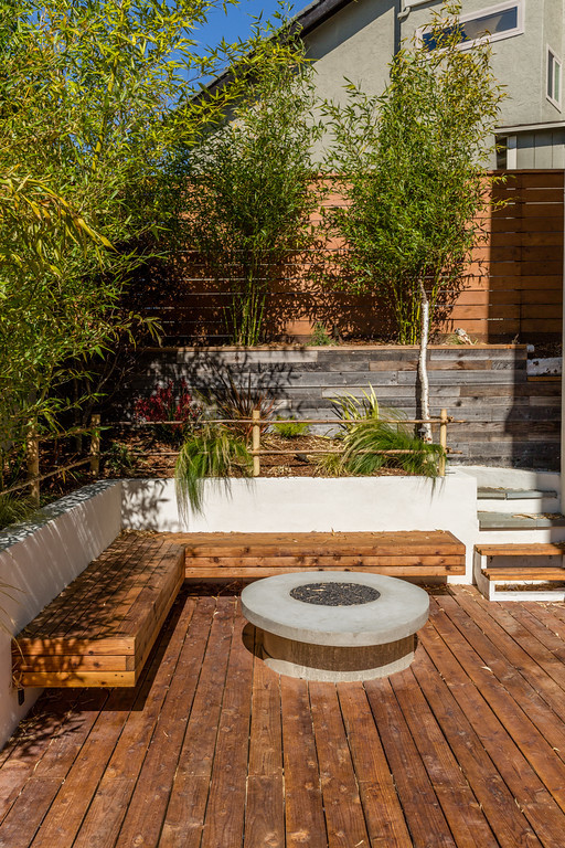 This is an example of a contemporary side yard deck in San Francisco with no cover and a fire feature.