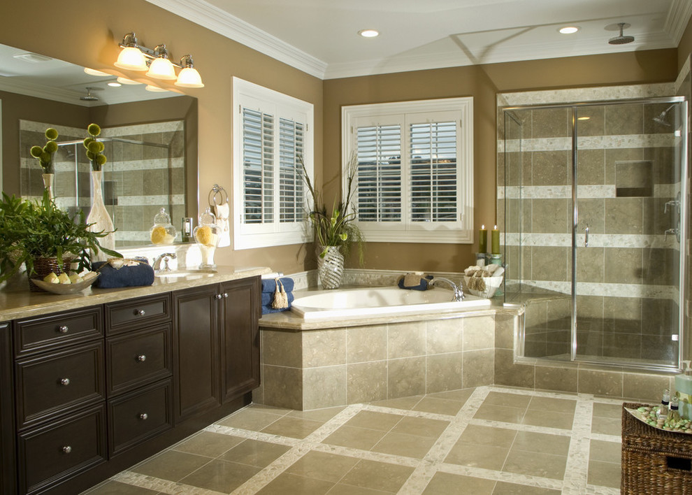 This is an example of a large traditional master bathroom in New York with beaded inset cabinets, dark wood cabinets, a corner tub, a corner shower, brown walls, porcelain floors, an undermount sink, granite benchtops, beige floor, a hinged shower door and beige benchtops.
