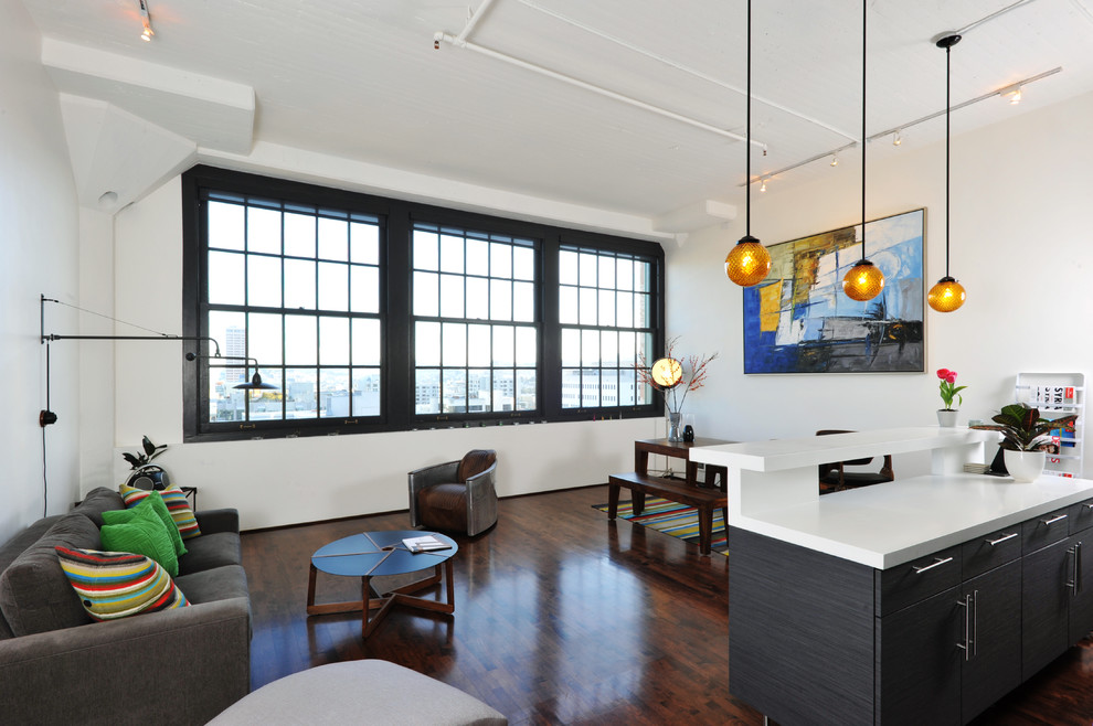 Photo of an industrial open concept living room in San Francisco with white walls.